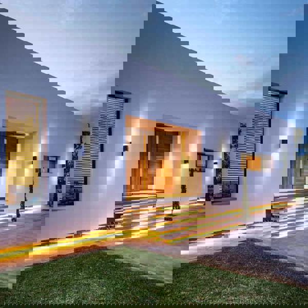 black outdoor up down light mounted in a row on the wall outside a modern home 