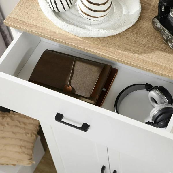 White cabinet drawer with black pull handle, holding stacked cookware and container items
