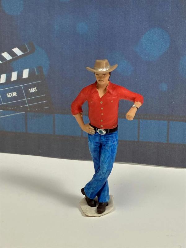 a toy figurine of a man wearing a cowboy hat