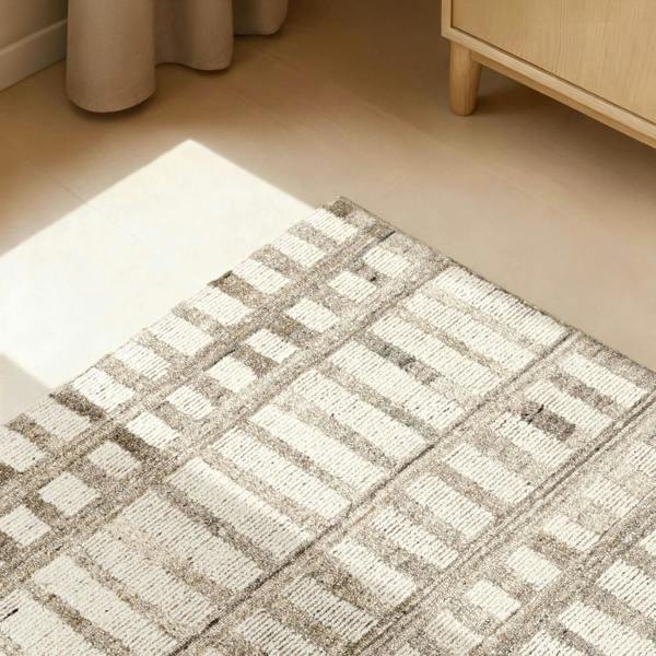 Patterned rug on a wooden floor with a light wood cabinet in the background