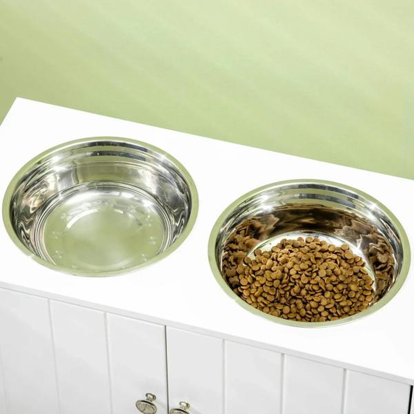 White raised pet feeder with two stainless steel bowls, one filled with kibble