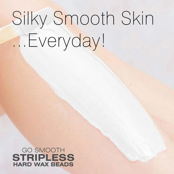 A close-up of a persons arm with a thick layer of white wax being applied. The text reads, Silky Smooth Skin ...Everyday! Rio Coconut Go Smooth Stripless Hard Wax Beads (100g).