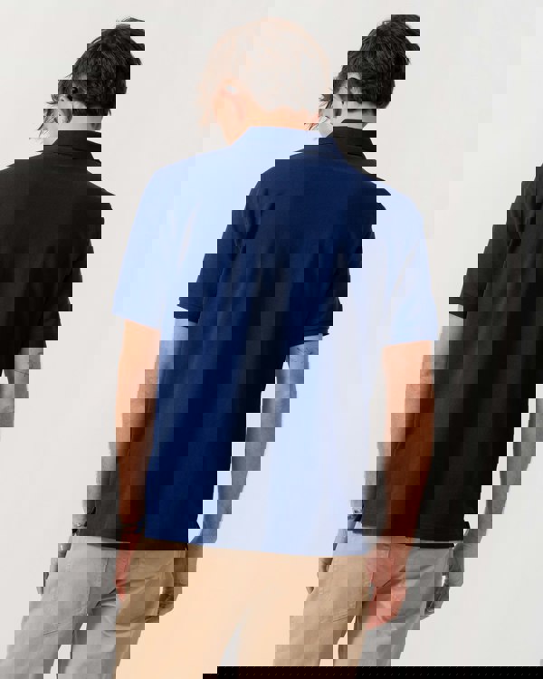 Model wearing GANT Mens Regular Fit Short Sleeve Shield Logo Pique Polo in 432 Rich Navy - Back