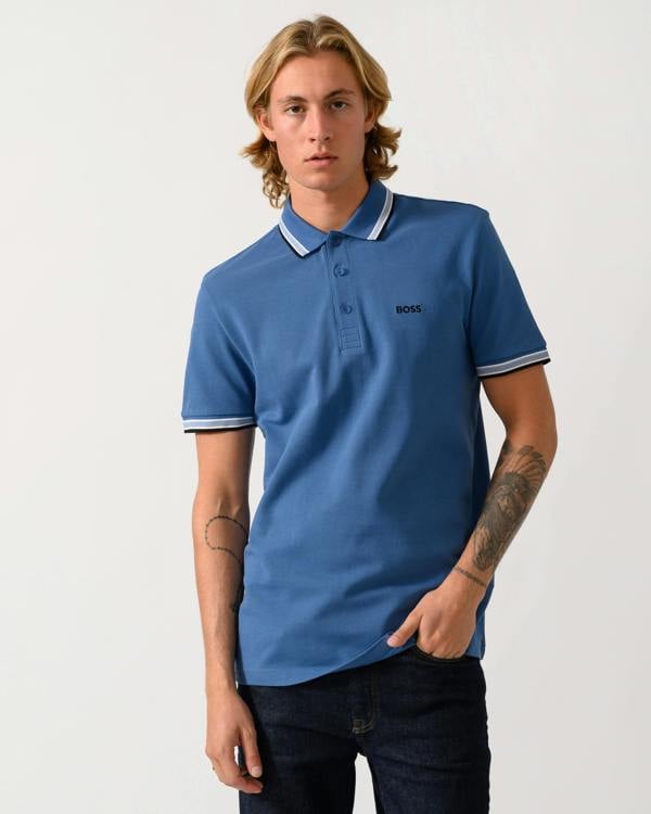 a studio photograph of a model wearing a BOSS Green Paddy Mens Cotton-Piqué Polo Shirt with Contrast Logo  in Medium Blue 428