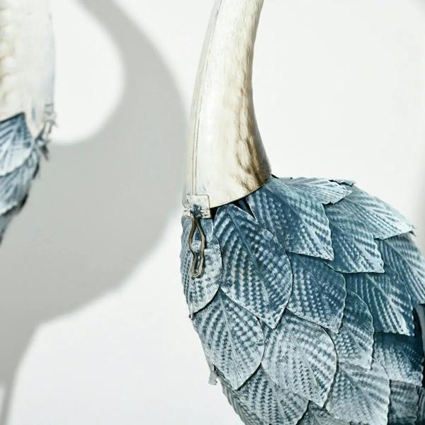 Steel crane ornament wing detail with blue scales and white tail feathers