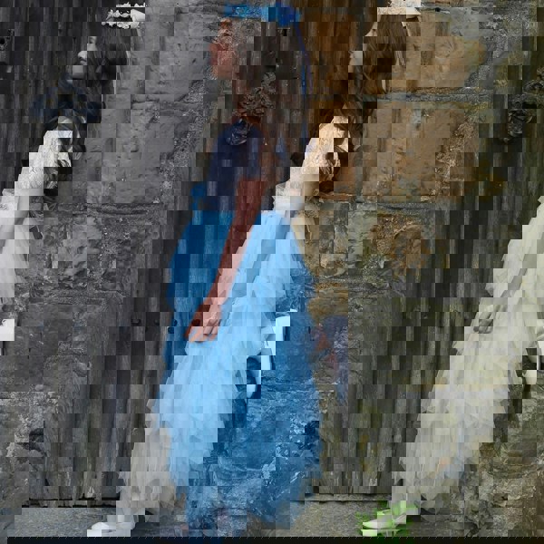 Girl standing in doorway with foot against wall