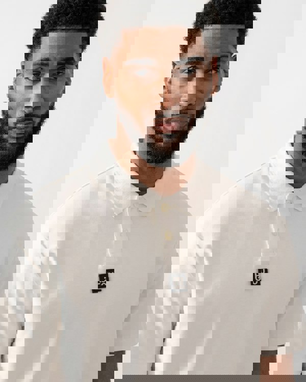 close up of a model wearing a HUGO Deabono Mens Interlock Cotton Polo Shirt with Stacked Logo in Natural white