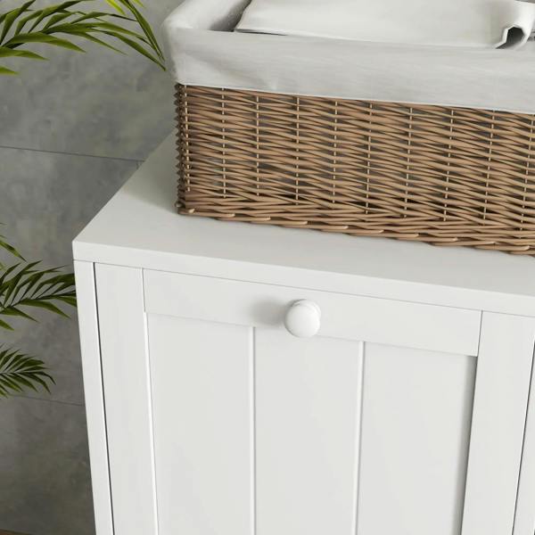Close-up of white cabinet front with paneled doors and round knob on top shelf.