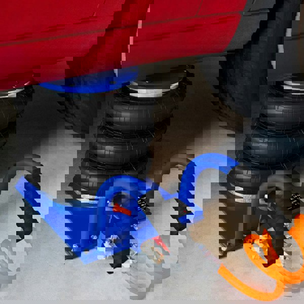 Air Bag Jack 3.5T with durable black rubber bags, blue carrying handle, and connected air hose, positioned under a vehicle