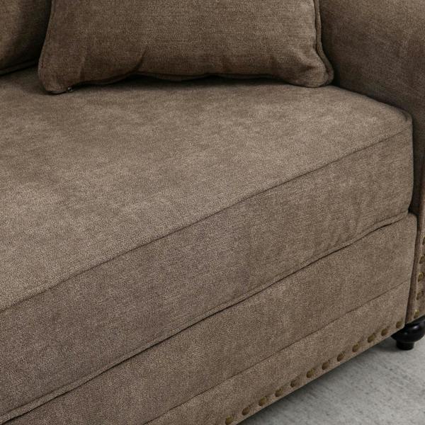 Brown fabric sofa arm and seat cushion with nailhead trim along the edge