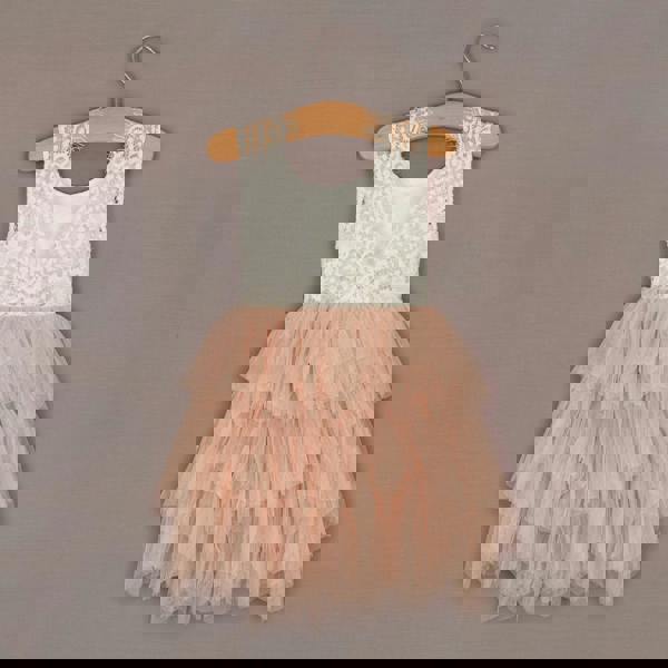 Lace top and layered tulle skirt dress on a hanger against a plain background