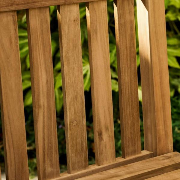Close-up detail of the multi-slatted seat and front legs of the solid teak chair.