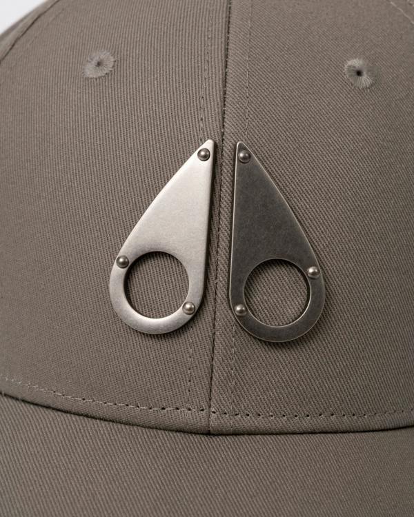 logo detail of a Moose Knuckles Front Logo Icon Cap in Ashen 1968