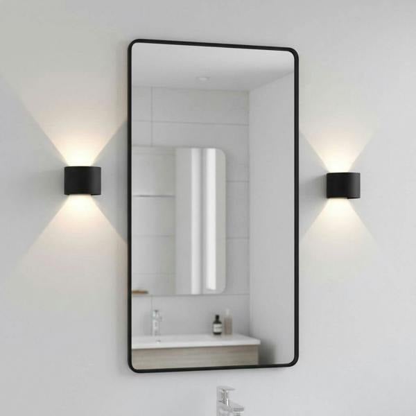 black bathroom wall sconce mounted either side of a bathroom mirror