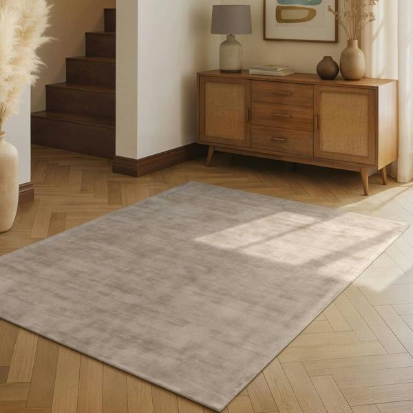 Light gray rug on a wooden floor with a wooden sideboard in the background.