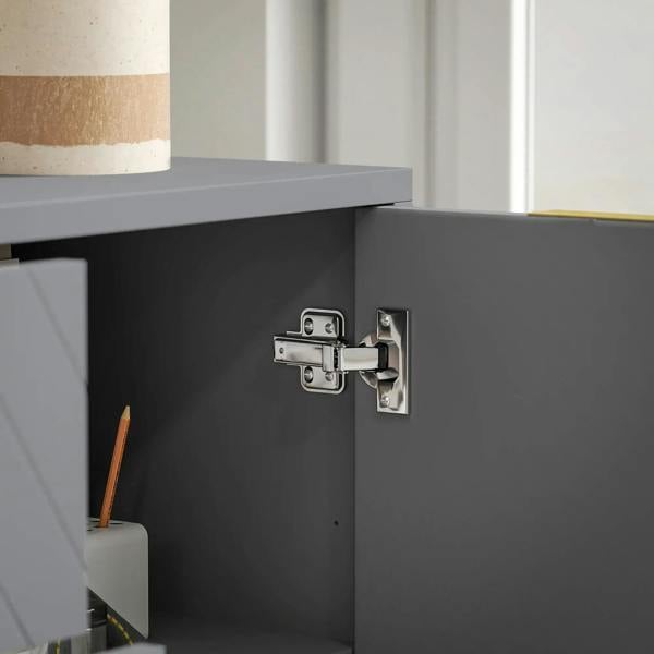 Grey sideboard cabinet door hinge and latch hardware over an empty interior