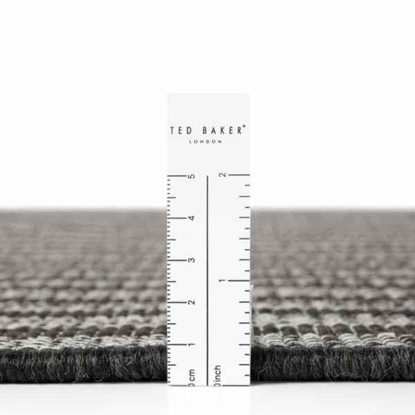 Gray textured rug with a ruler and 'Ted Baker' branding on a white background