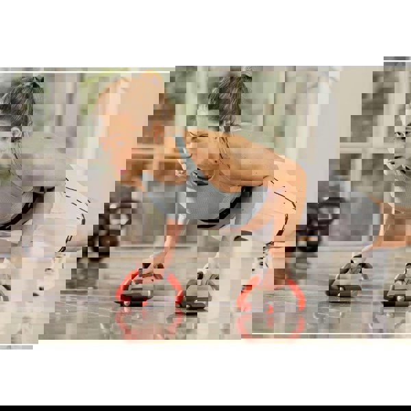 Woman doing push ups using Reebok Push Up Bars in the gym