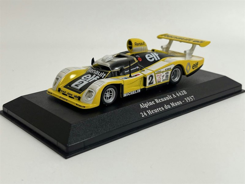 a yellow toy car on a black stand