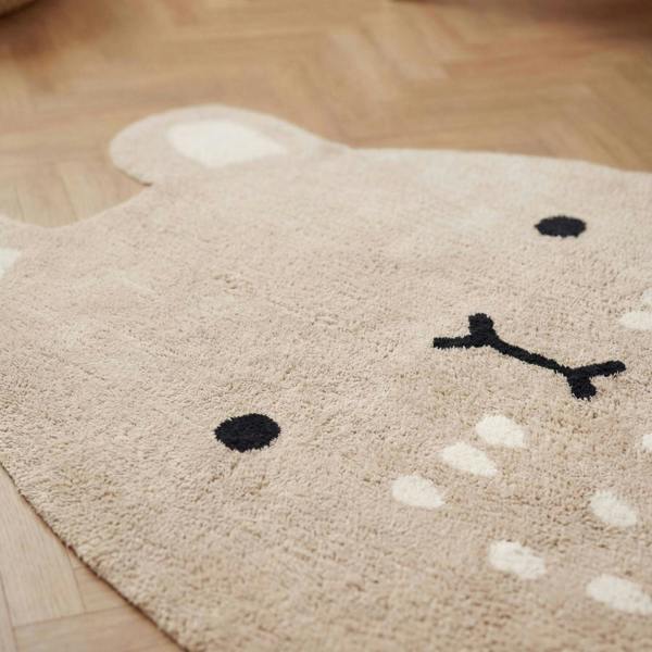 Beige rug with a bear face design on a wooden floor
