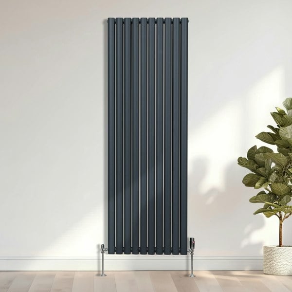 Sleek chrome thermostatic radiator valves with a modern design, paired with a tall, slim black vertical radiator against a light wall