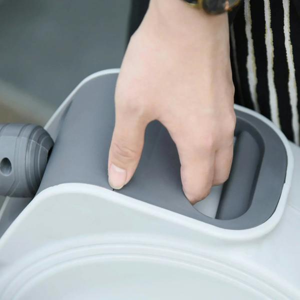 Hand inserting hose end into the inlet opening of a white retractable air hose reel