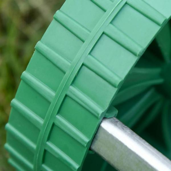 Green rolling drum segment with metal axle on a lawn aerator roller