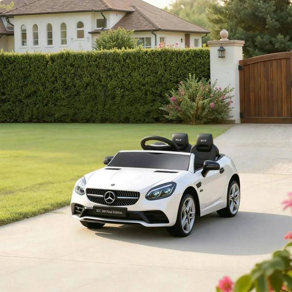 White kids electric ride-on car on a driveway with LED headlights and sporty wheel design.