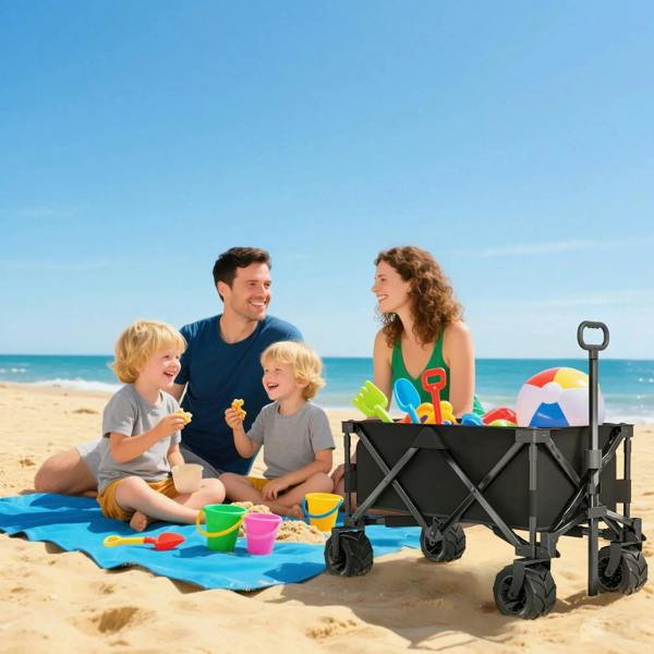 Black folding cargo wagon cart with pull handle and four rugged wheels on sand