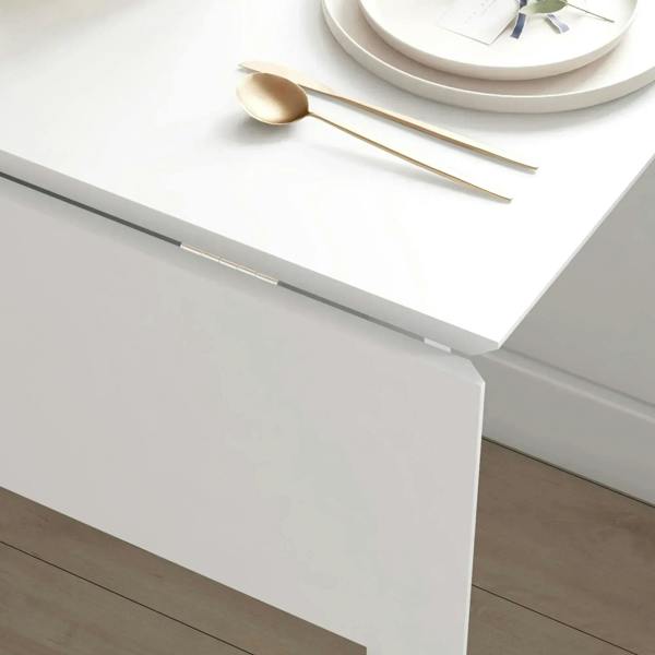 Close-up of white folding table edge and hinge hardware on the tabletop