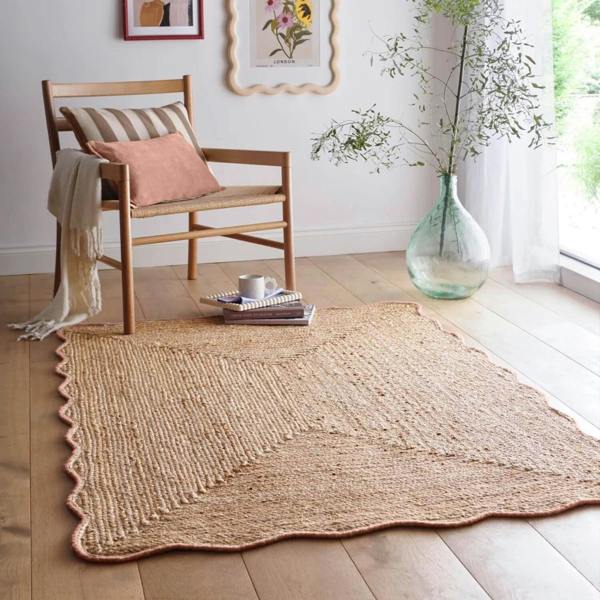 Natural fiber rug on a wooden floor with a chair and decorative elements.