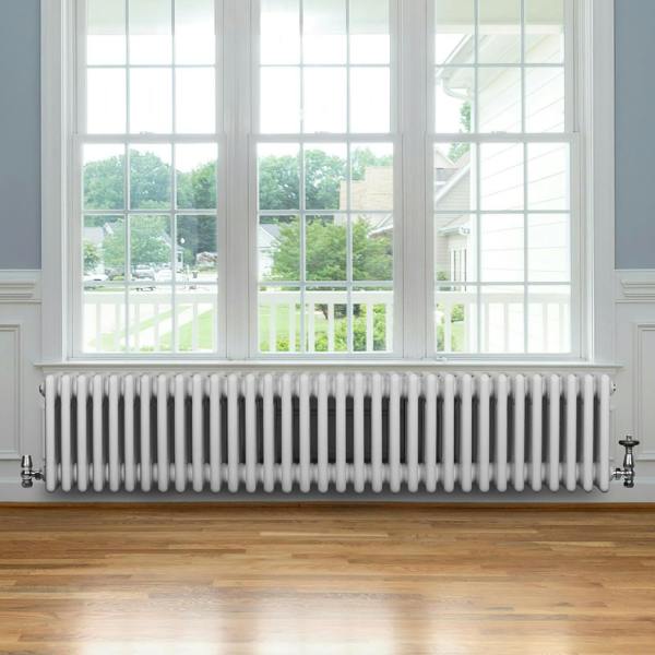 Traditional white 4 column radiator with valves, featuring a sleek design and smooth finish, positioned under a large window