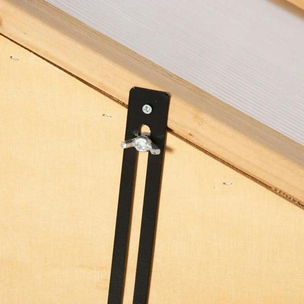 Close-up of black metal latch/hinge on wooden cold frame greenhouse door