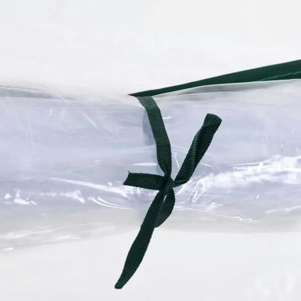 Clear greenhouse cover secured with dark green tie straps at the arched frame