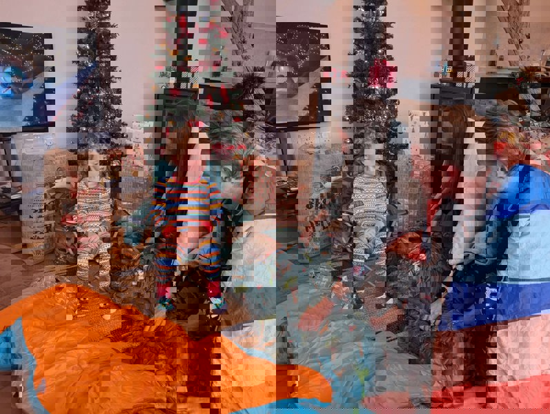 unwrapping image for Kids Camping Chair by OLPRO, pictured as an Ideal Christmas Present with family.