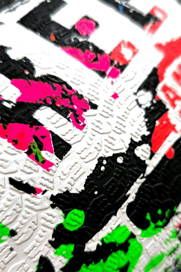 Macro close-up of graffiti paint-splatter surface on Optimum Street football - Optimum