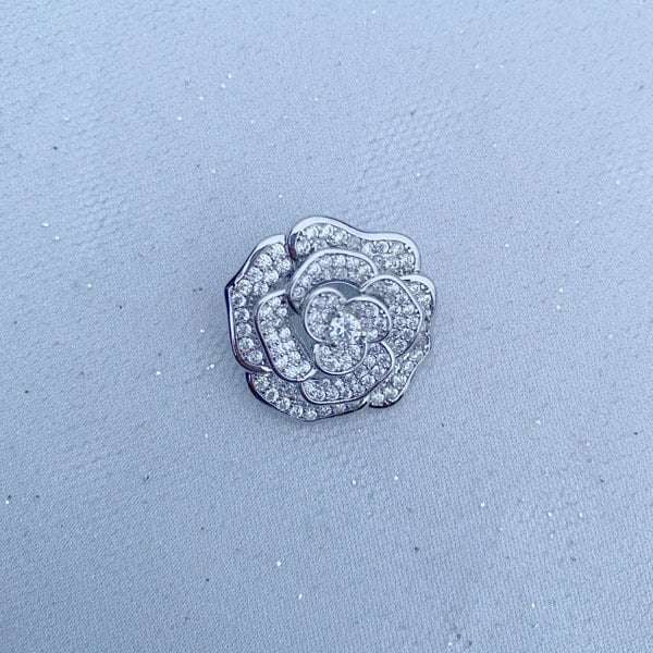 Silver brooch, rose flower design, pavé diamante detailing, layered petals, sparkling crystal embellishments, polished silver tone finish, vintage inspired decorative accessory
