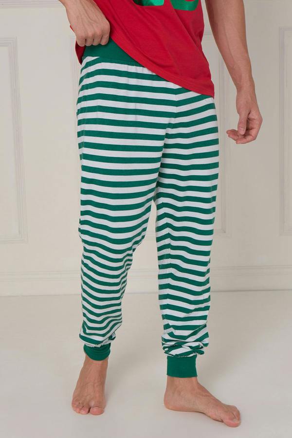 Person wearing green and white striped pants with a red top against a white background