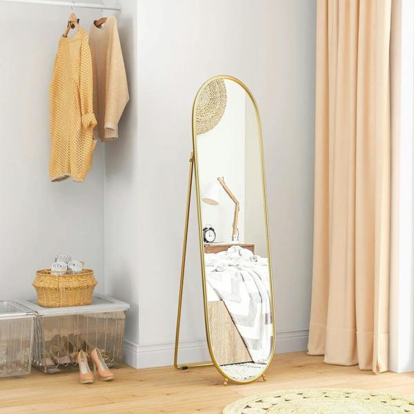 Gold-tone two-way oval full-length mirror with arched frame and narrow stand legs.