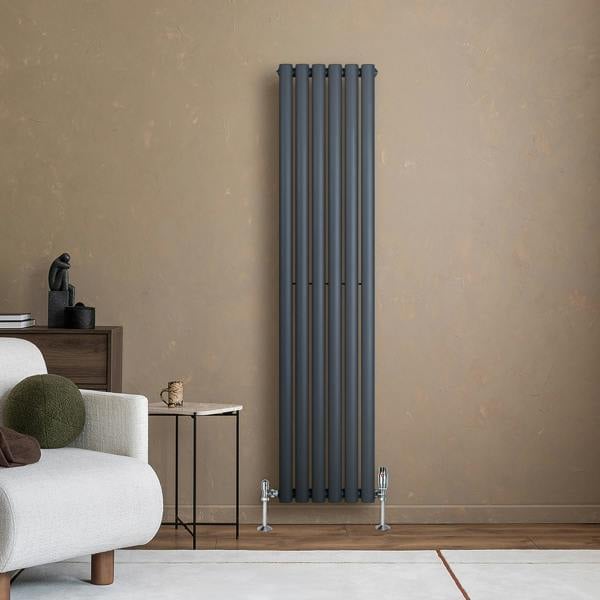 Anthracite grey oval single column radiator, 1600 x 360mm, mounted on a textured wall, complementing modern interior decor