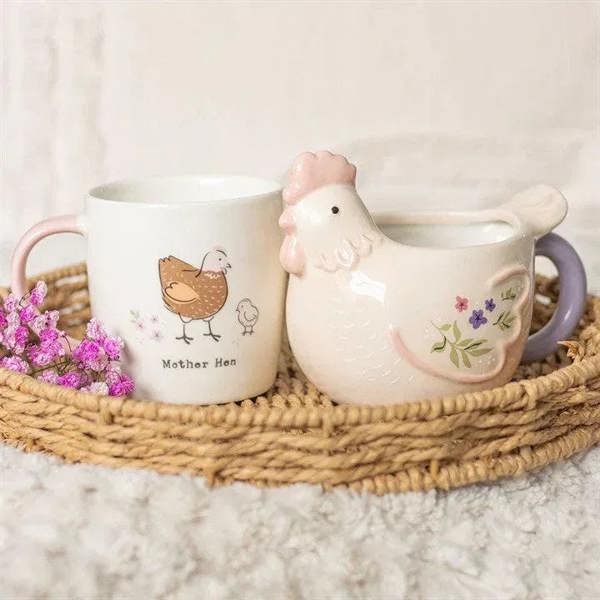 Hen-themed mug set on tray: white mug with pink handle and mother hen, plus purple bird mug.