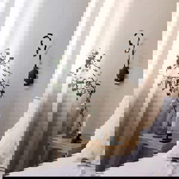 black flexible LED reading light installed next to a bed in a modern bedroom