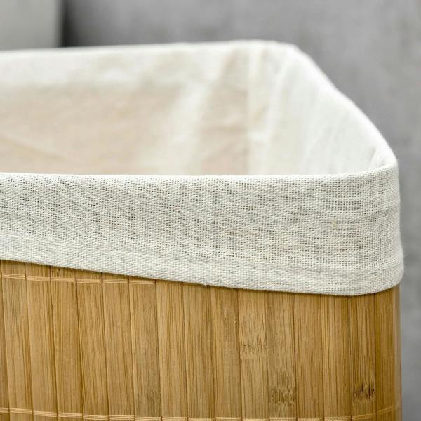 Close-up of white fabric lining top edge on bamboo laundry hamper.