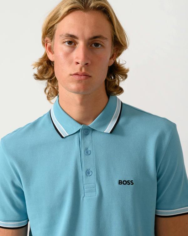 close up studio photograph of a model wearing a BOSS Green Paddy Mens Cotton-Piqué Polo Shirt with Contrast Logo in Open Blue 486