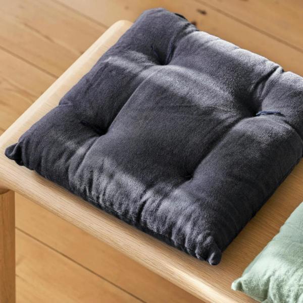 A top-down angled view of the Carbon grey 100% linen seat pad on a light wood bench.