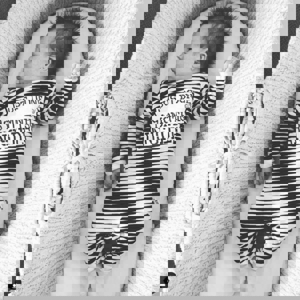 Baby laying in crib wearing Just Done 9 Months Inside baby grow