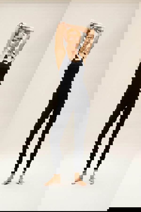 Model wearing black one piece for sustainable activewear brand, JillaBlack seamless sculpting shaping one piece bodysuit with built in shelf bra and removable pads for yoga, pilates, gym and exercise.