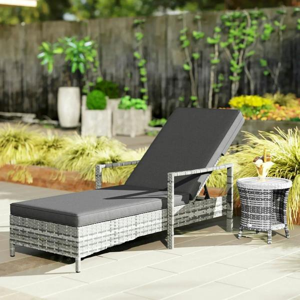 Grey patio rattan sun lounger with dark cushion and angled adjustable backrest