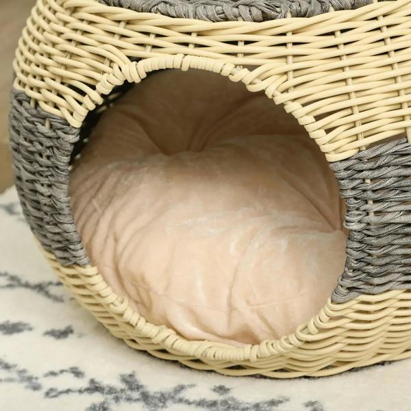 Inside view of round wicker cat house showing beige cushioned sleeping area.