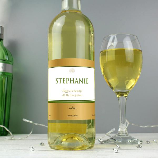 Personalised White Wine bottle with a custom gold label next to a glass of white wine.